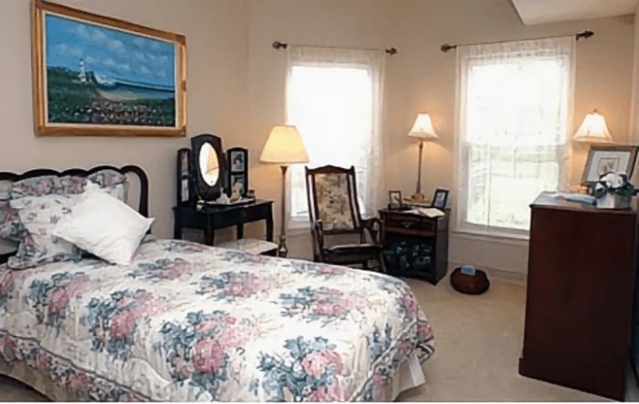 A cozy bedroom featuring vintage furniture, floral bedding, and soft natural light streaming through the windows.