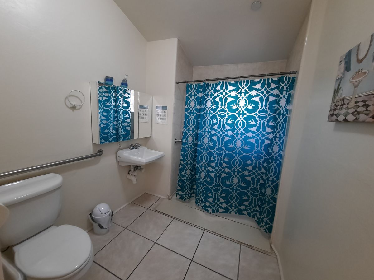 A clean and simple bathroom with a blue patterned shower curtain.