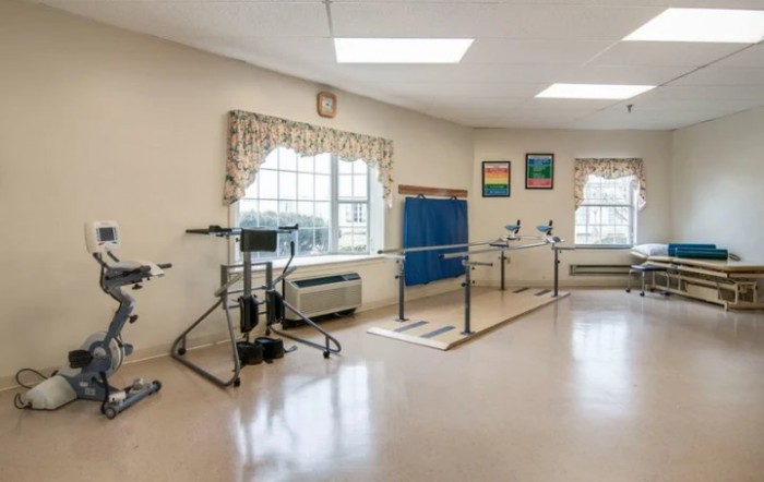 A therapy room equipped with parallel bars and other rehabilitation equipment.