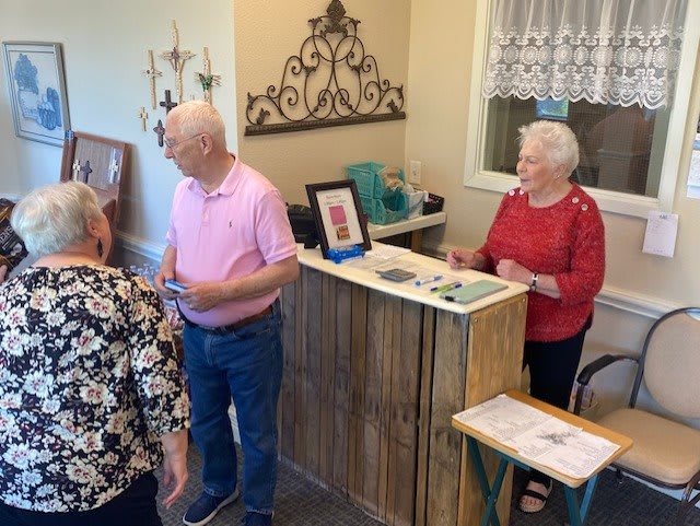 A group of people gathered around a reception desk, engaging in conversation.