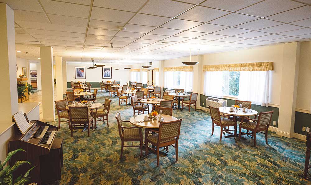An empty dining room with neatly arranged tables and chairs.