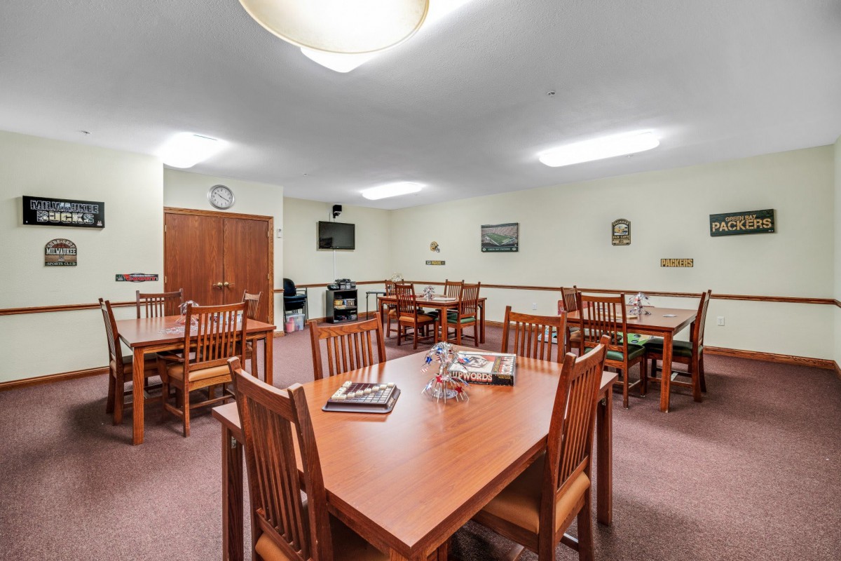A well-lit dining area with wooden tables and chairs, suitable for communal gatherings.