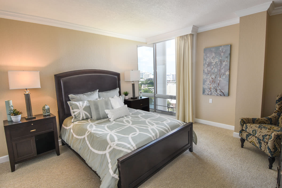 Modern bedroom with stylish decor and large window.
