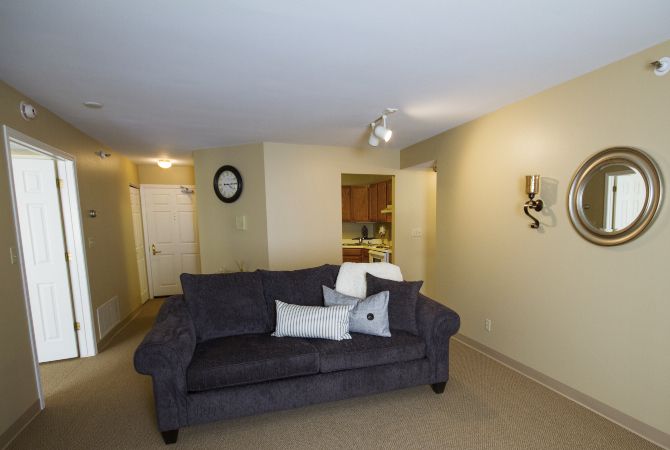 A modern living room with a plush sofa and simple decor.