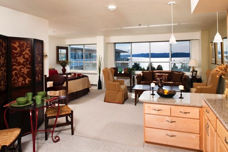 A spacious open-plan living area with modern furniture and large windows offering a scenic view.