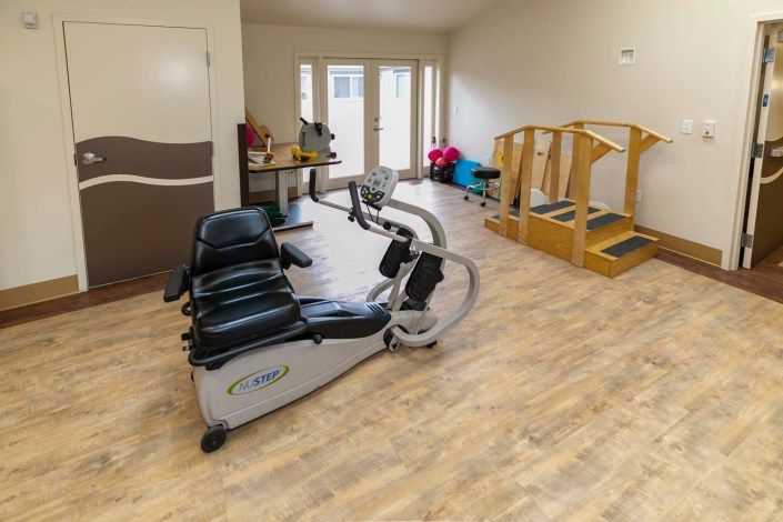 A rehabilitation room equipped with exercise machines and physical therapy equipment.