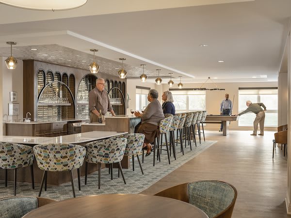 A modern cafe interior with people seated around a bar counter.
