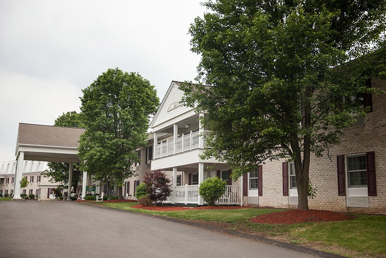 A scenic view of a building with surrounding trees and well-maintained landscaping.