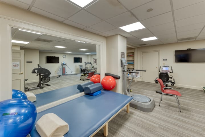 A well-equipped physical therapy room with exercise gear and rehabilitation tools.