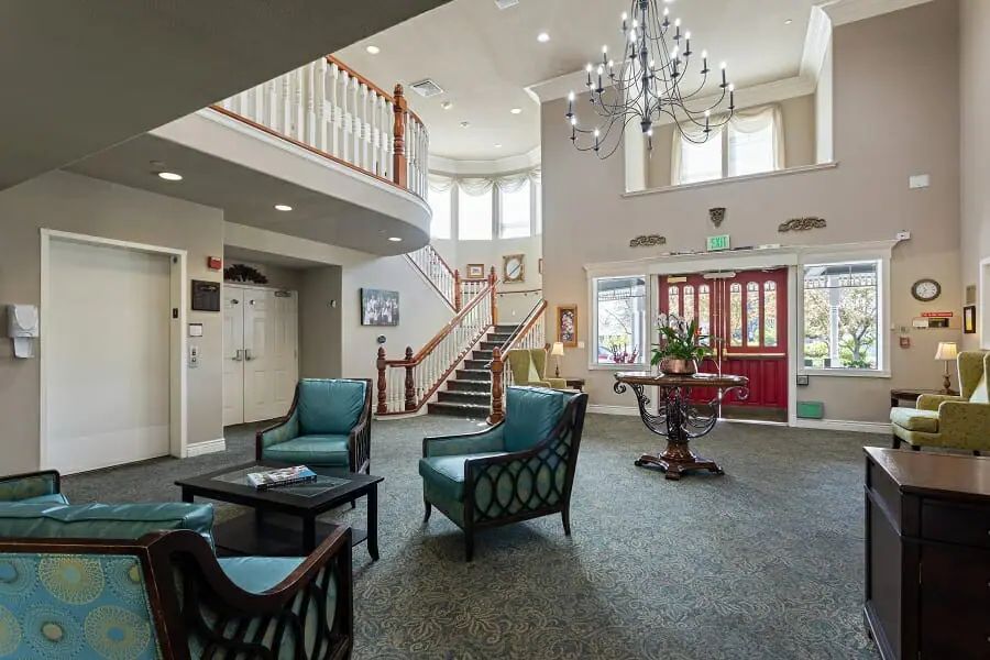 A spacious and well-lit lobby with elegant furniture and a chandelier.