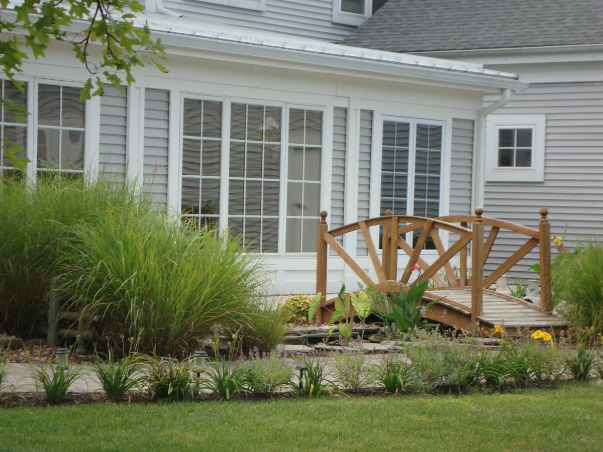 A backyard view featuring a small wooden bridge and well-maintained garden.