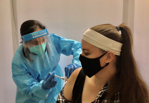 A healthcare professional administering a vaccine to a patient in a safe environment.
