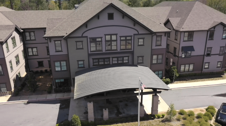 A modern residential building with a covered entrance and multiple windows.
