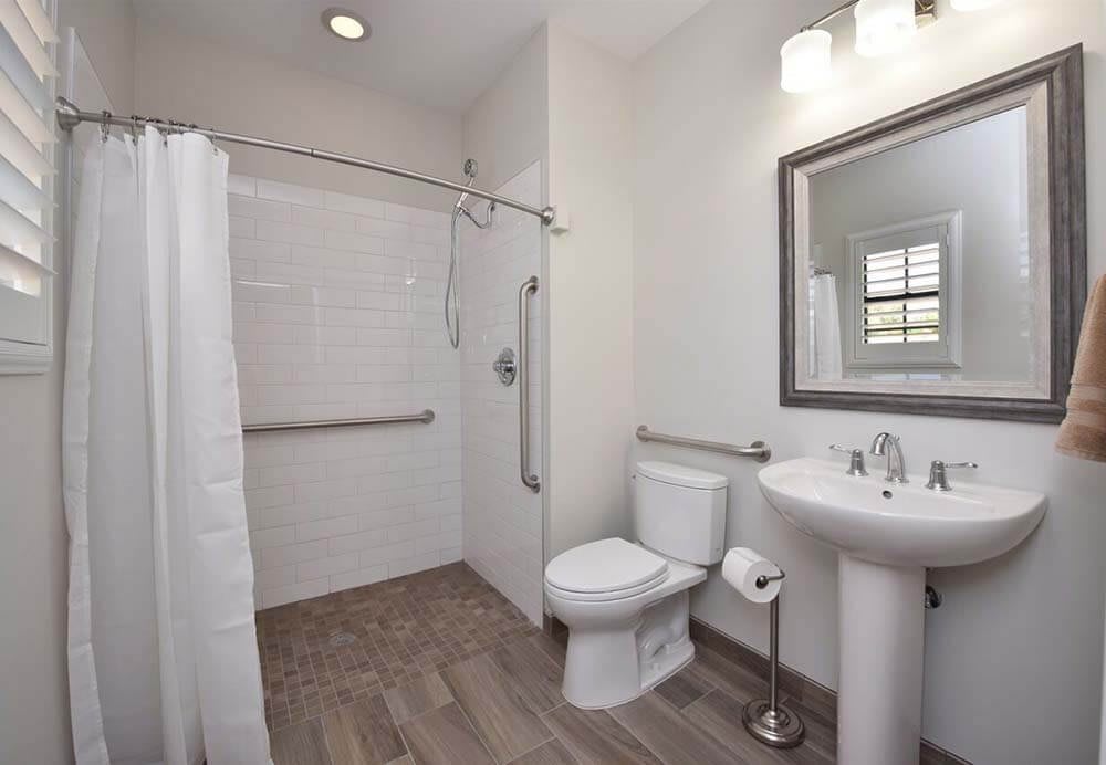 A modern bathroom with a shower, toilet, and sink.