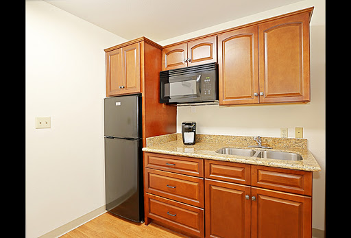 A modern kitchen featuring wooden cabinets and essential appliances.