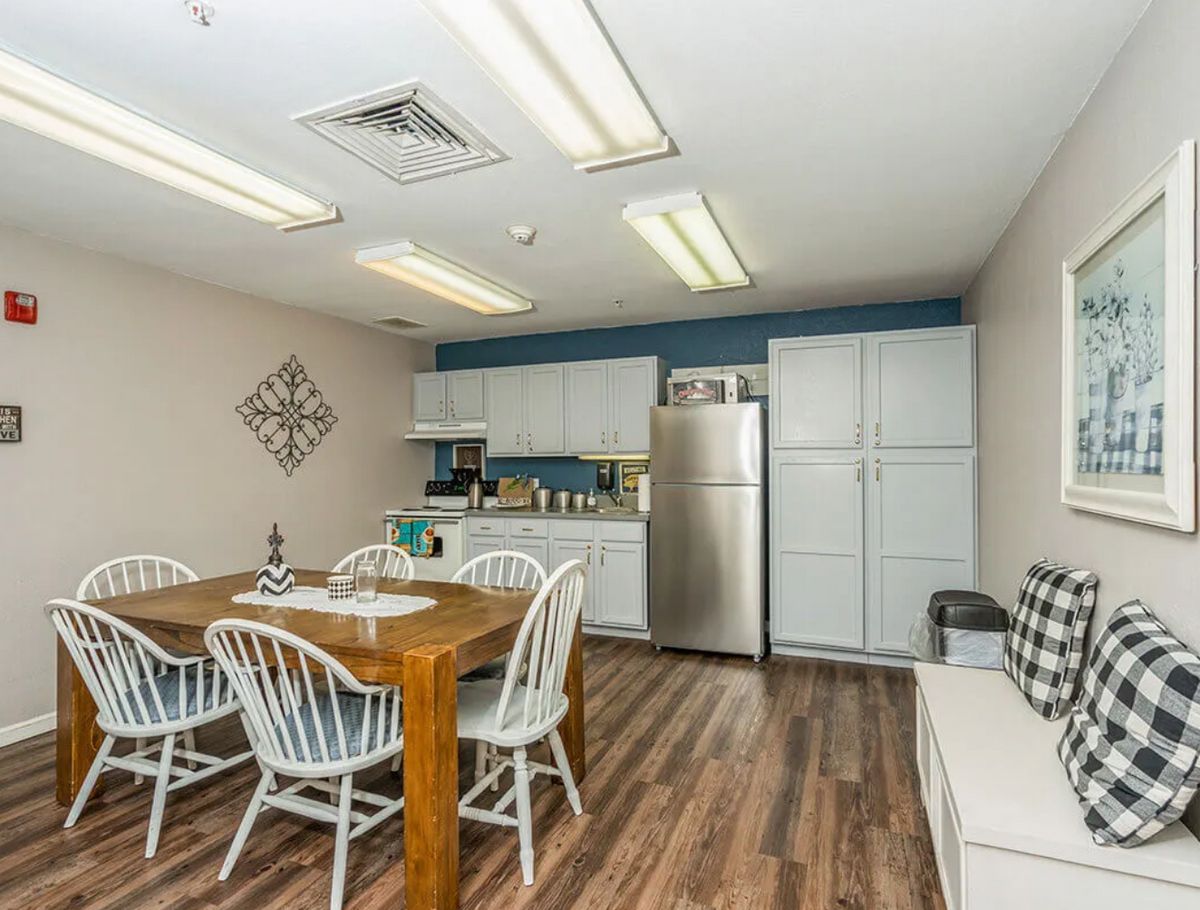 A cozy kitchen and dining area featuring a wooden table with chairs, modern appliances, and ample cabinetry.