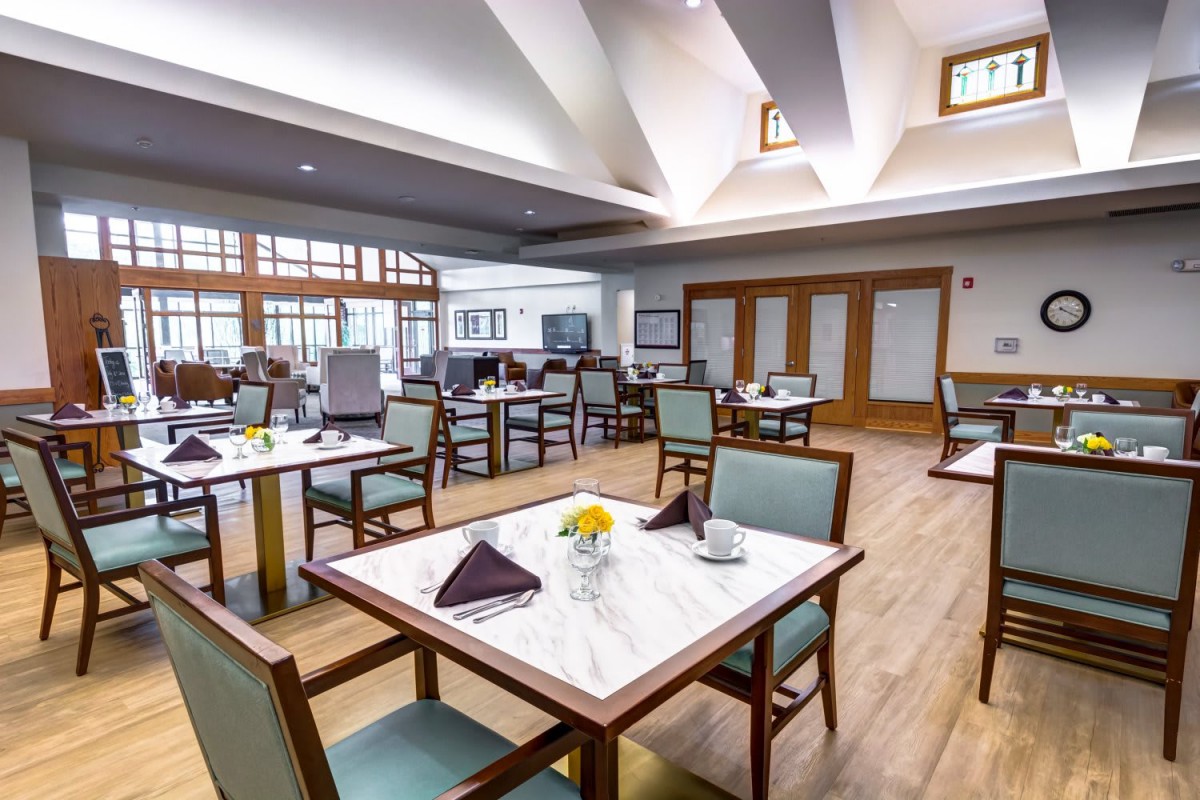 A spacious and elegantly designed dining area with neatly arranged tables and chairs.