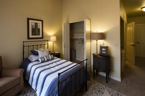 Cozy bedroom with a striped bedspread and warm lighting.