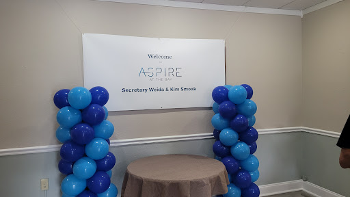 A welcoming setup for the ASPIRE event, featuring blue and purple balloons.