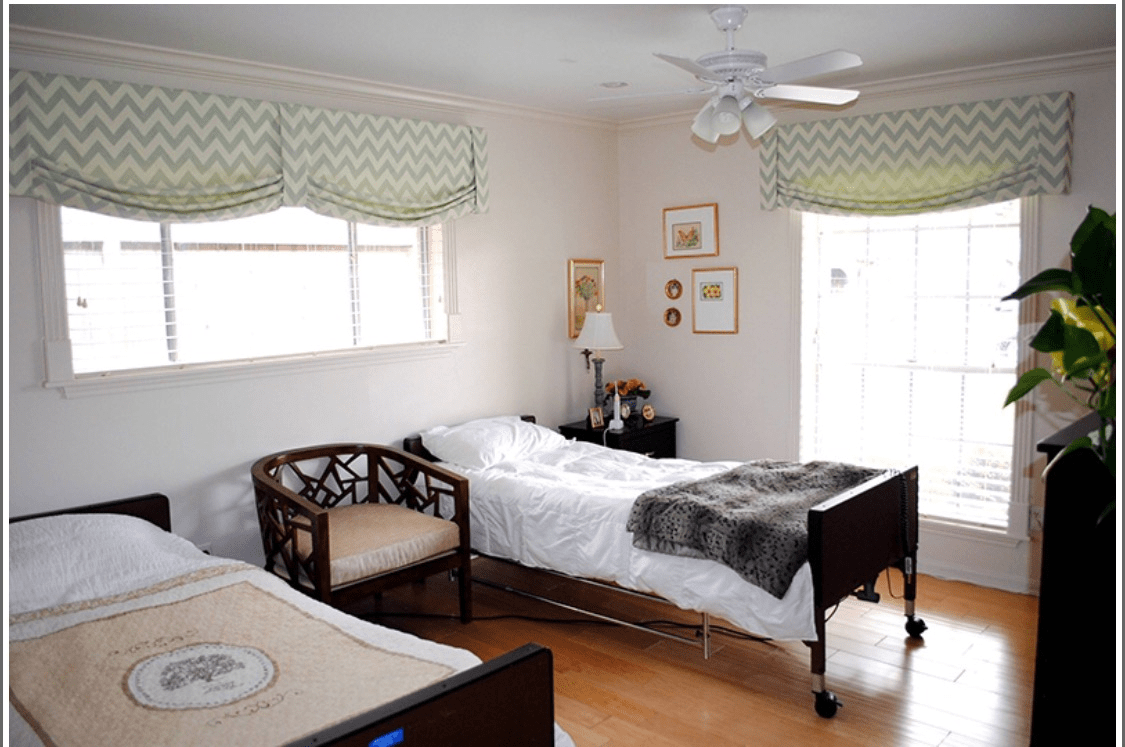 A cozy bedroom with twin beds, a chair, and soft lighting.