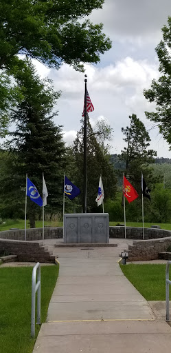 A memorial dedicated to veterans, featuring the American flag and various service flags.