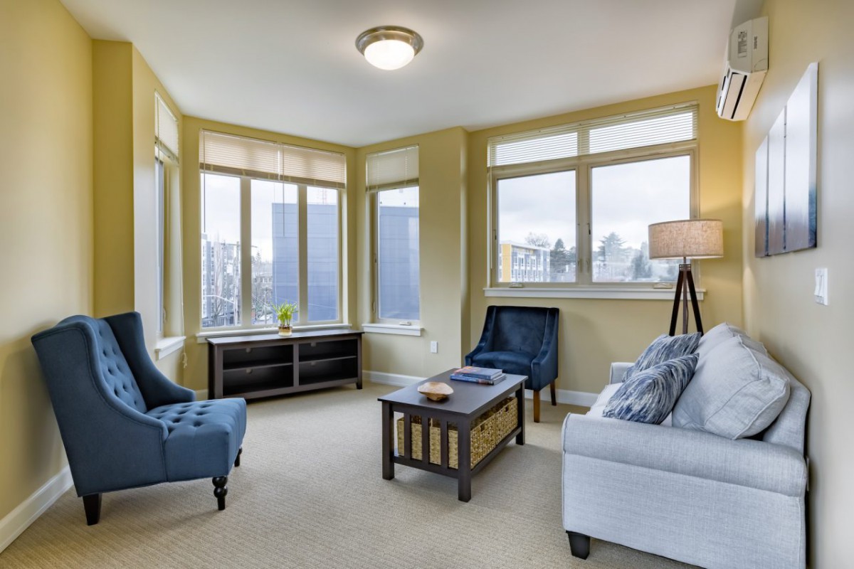 A cozy living room with comfortable seating and large windows allowing natural light to fill the space.