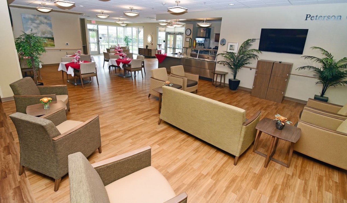 A spacious and modern lounge area with comfortable seating, a television, and ample natural light.