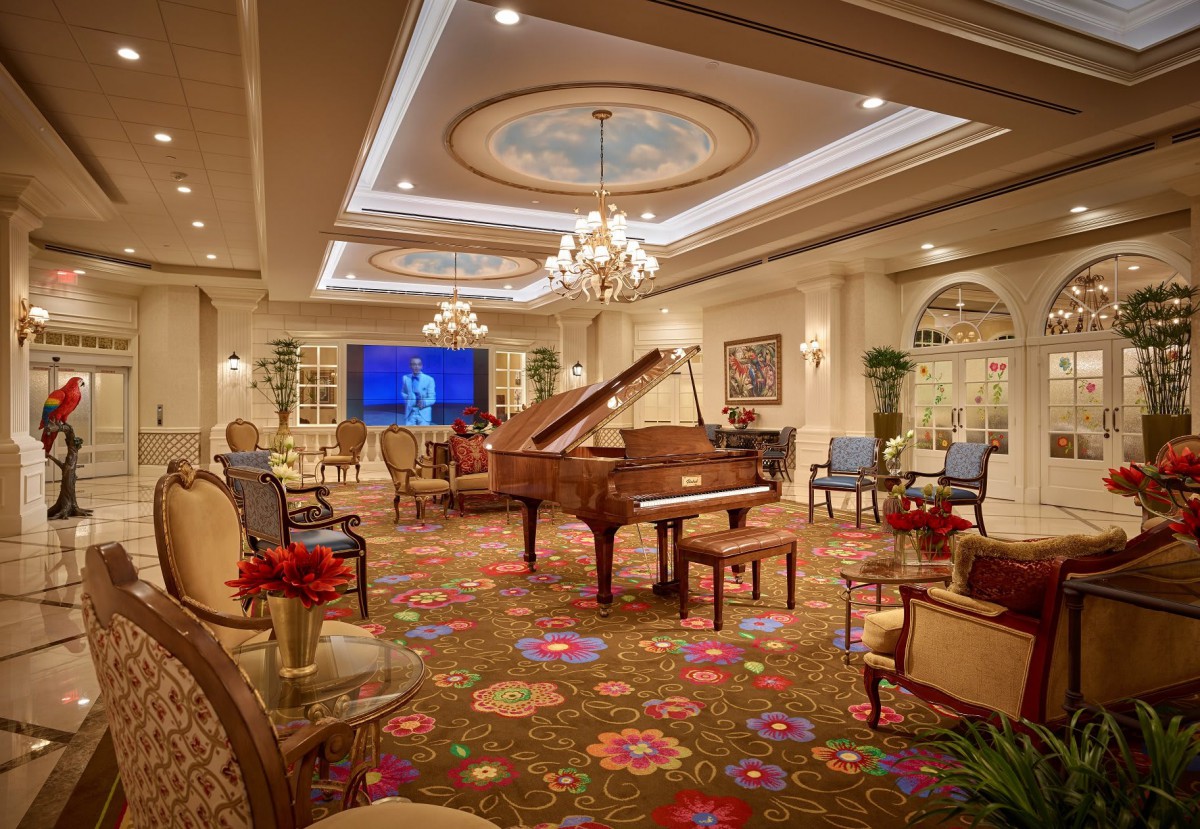 A luxurious living room with a grand piano and elegant decor.