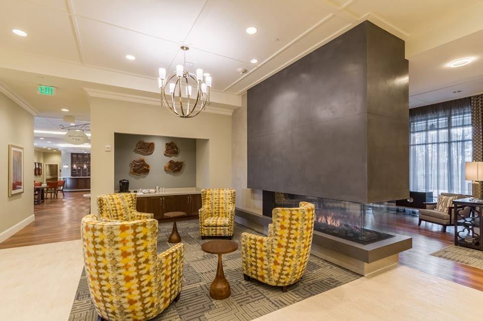 A modern lobby interior featuring a stylish fireplace and comfortable seating area.