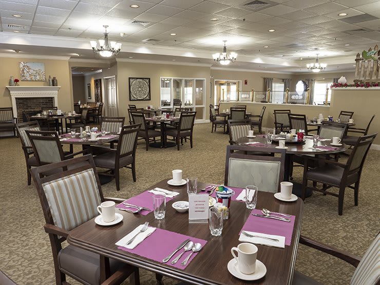 An elegant dining room with neatly arranged tables and place settings, ready for guests.