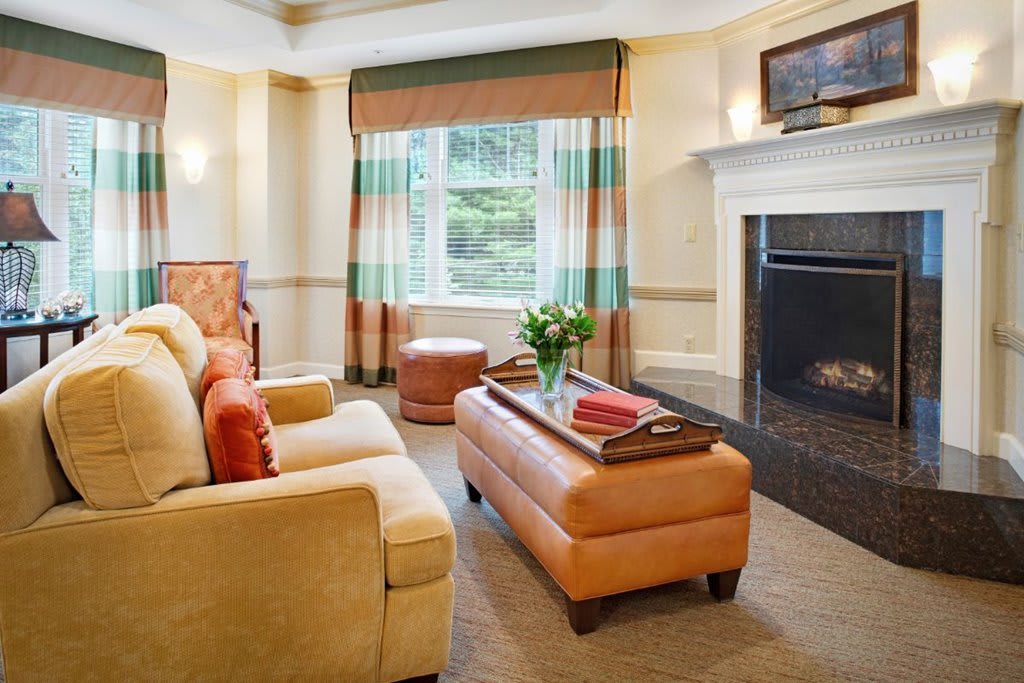 A cozy and elegantly decorated living room with a fireplace, comfortable sofa, and a well-designed coffee table.