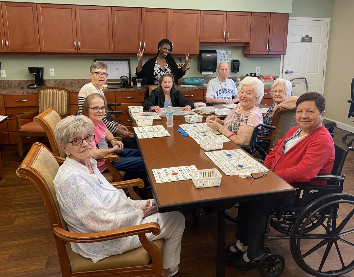 A group of seniors gathered around a table for a community activity, smiling and enjoying their time.
