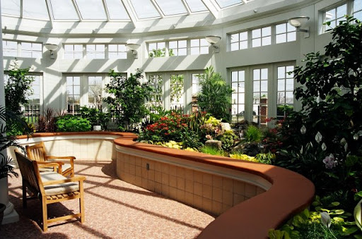 A bright and inviting sunroom filled with lush plants and natural light, creating a serene relaxation area.