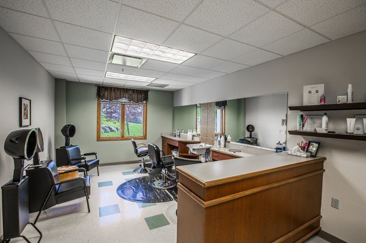 A hair salon interior with chairs and mirrors arranged neatly.