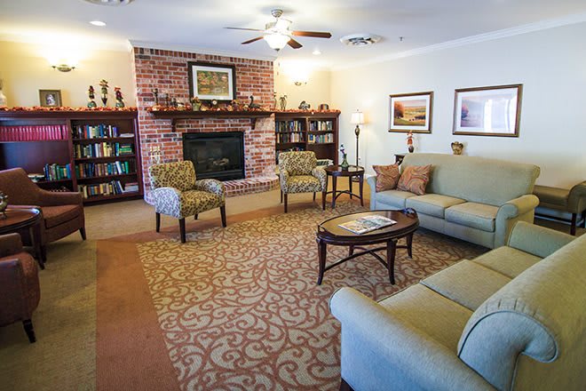 Cozy living room with a brick fireplace, comfortable seating, and elegant decor.