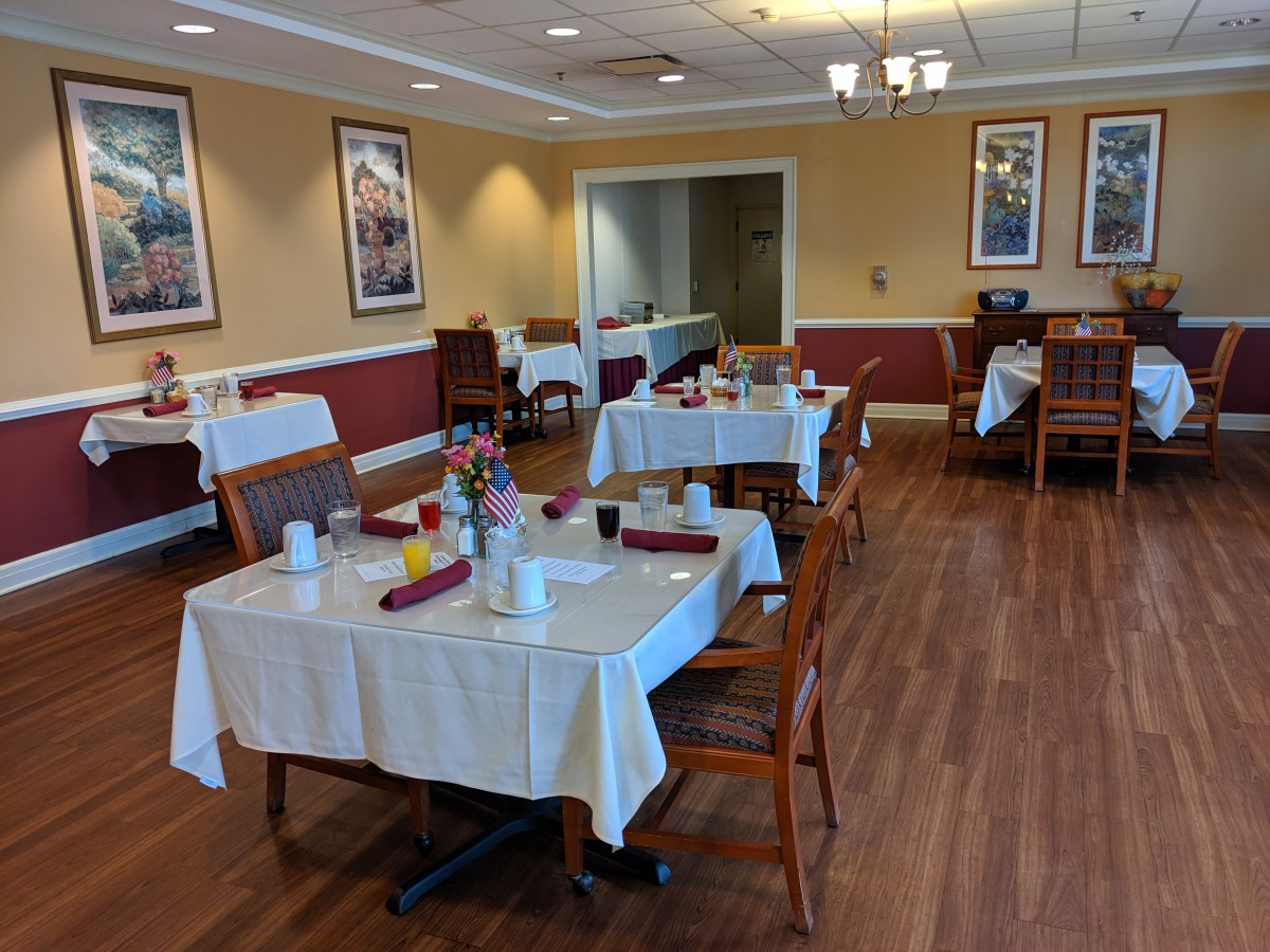 A neatly arranged dining area with tables set for service in a cozy restaurant.