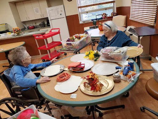 Two seniors engaging in a creative activity at a community center.