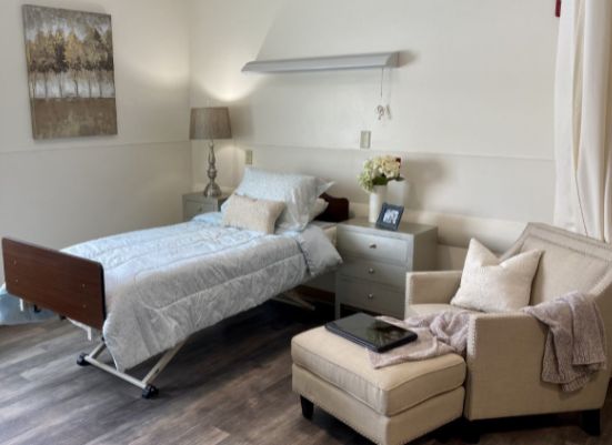 A well-decorated, cozy room featuring a hospital bed and a comfortable armchair.