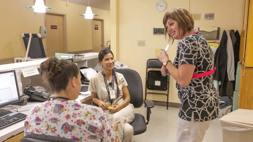 A group of medical professionals having a conversation in a hospital setting.