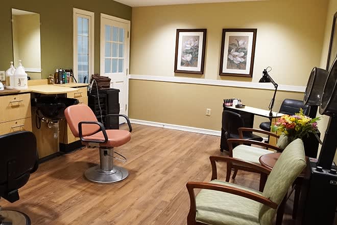 A neatly arranged office space with a chair and desk, featuring framed artwork on the wall.
