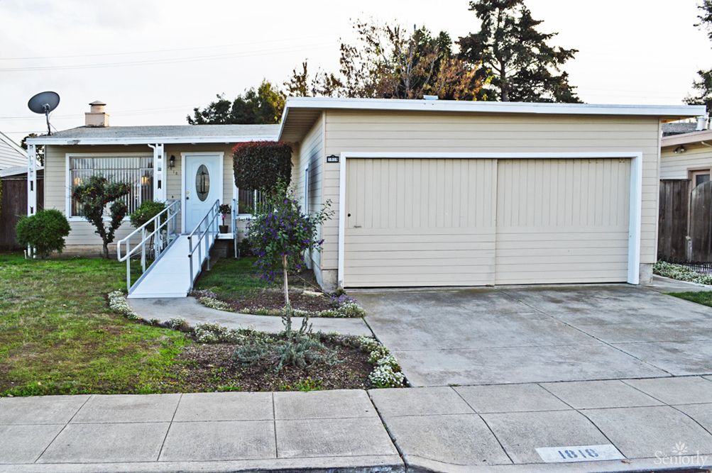 A suburban house with a garage and a ramp leading to the front door.