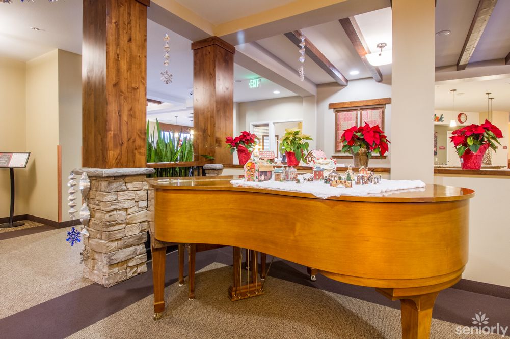 A beautifully decorated room featuring a grand piano adorned with festive holiday decor.