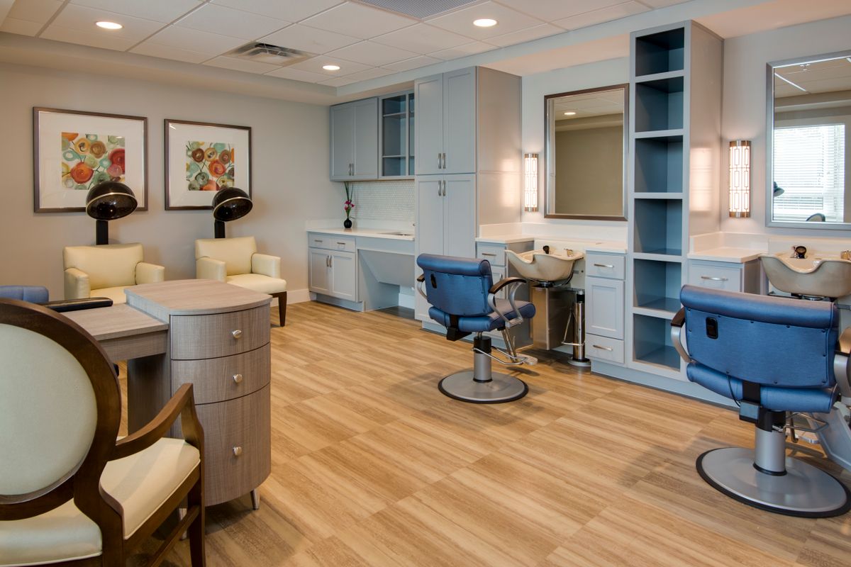 A modern salon interior with styling chairs, mirrors, and workstations.