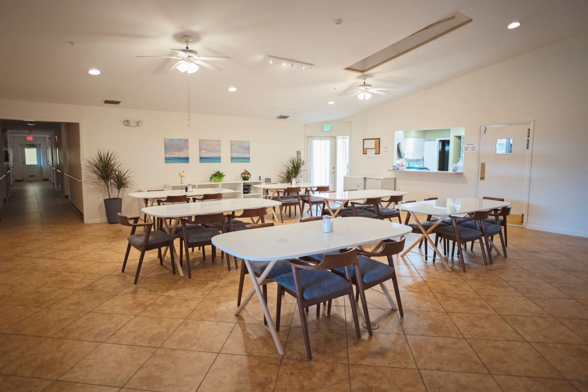 A spacious dining area with multiple tables and chairs, ready for use.