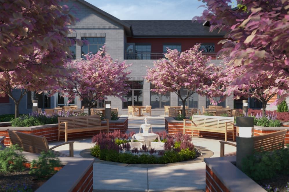 A serene courtyard featuring a central fountain surrounded by blossoming trees and benches.