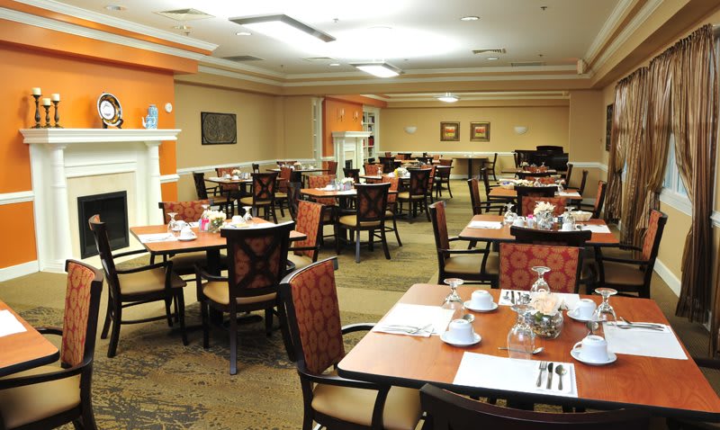 A well-appointed dining room with neatly arranged tables and chairs, featuring elegant place settings.