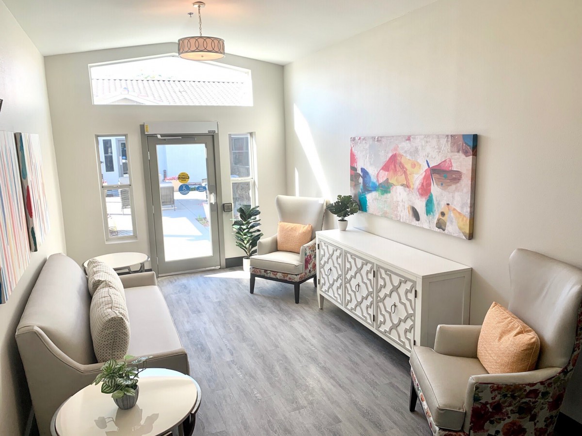 A modern and bright living room with stylish furniture and colorful artwork.