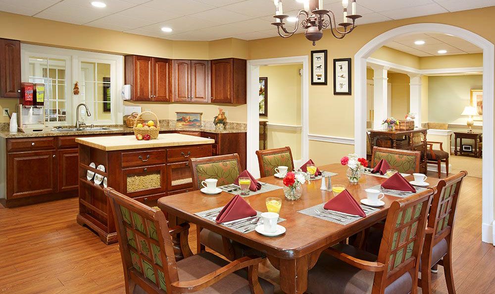 A cozy dining area with a set table adjacent to a kitchen.