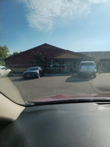 A view of a parking lot with several cars parked in front of a building on a sunny day.