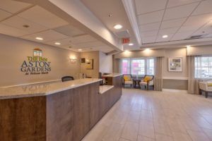 A hotel reception area with a check-in desk and seating space.